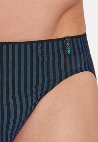 Herrensimtröjor i svart med vertikala blå ränder. Har ett mjukt tyg, en formad design och en märkesresårmidja.