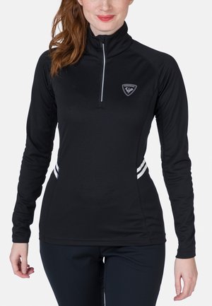 Schwarzes langärmliges Oberteil mit Viertelreißverschluss, tailliertem Design, strukturiertem Stoff und weißen Streifenakzenten an den Seiten; mit einem Logo auf der Brust.
