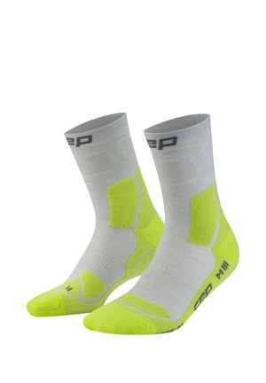 Pair of mid-calf gray socks with neon yellow cushioning on toes, heels, and sides, featuring a black logo near the top and sole.