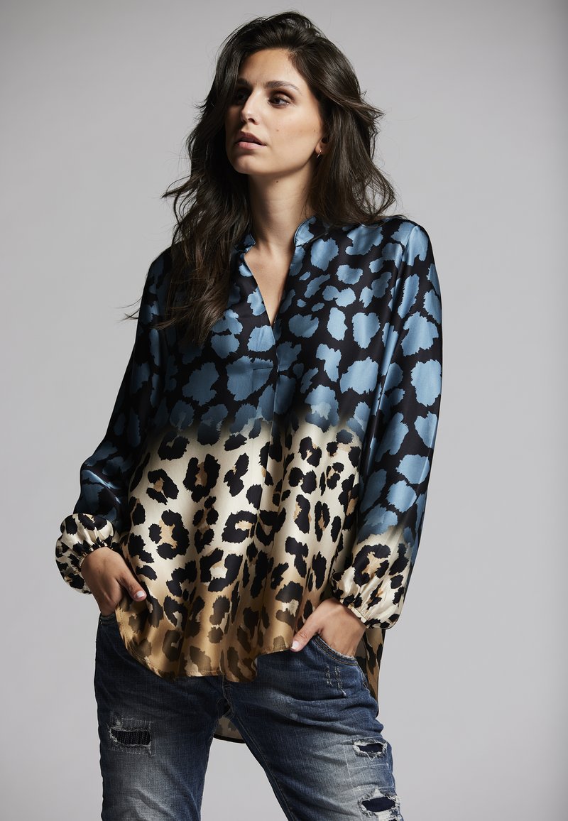 Long-sleeve blouse in blue and gold leopard print, featuring a collar, cinched cuffs, and a soft, glossy fabric with a relaxed fit.