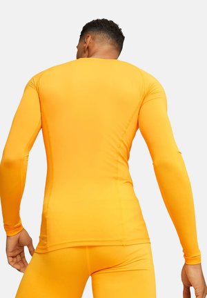 Langärmliges Athletikoberteil in leuchtendem Orange, aus glattem, elastischem Material mit flachen Nähten für Komfort, entworfen für aktive Bekleidung.