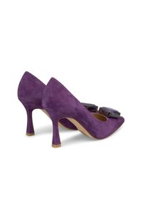 Fioletowe zamszowe szpilki z noskiem w szpic i dekoracyjnymi kryształowymi akcentami na wierzchu. Smukła pięta w stylu stiletto.
