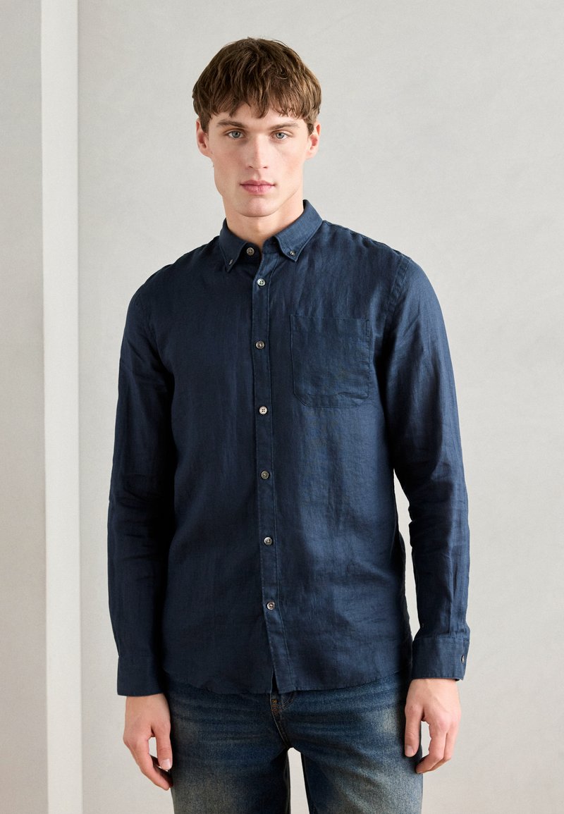 Navy blue button-up shirt in lightweight fabric, featuring a pointed collar, chest pocket, and long sleeves with buttoned cuffs.