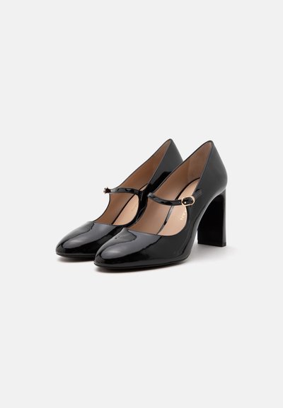 Paire de chaussures Mary Jane à talons hauts en cuir verni noir, avec des bouts arrondis et une fine bride à boucle sur le devant.