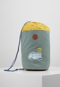 Sac à dos à cordon avec un haut jaune et un corps vert. Il présente un patch de van aménagé bleu et un logo en cuir marron à l'avant.