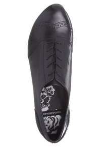 Chaussure Oxford en cuir noir avec des détails à motif brogue, laçage fermé, et semelle intérieure à motif floral portant la marque "VAGABOND".