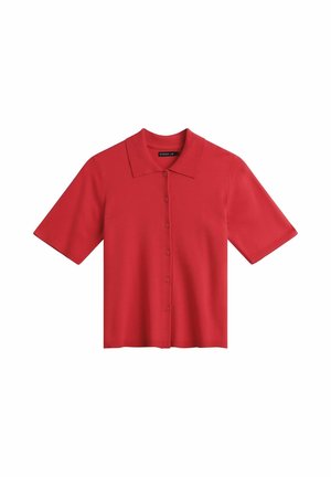 Chemise rouge à manches courtes avec boutons et col, en tissu tricoté, présentée à plat sur un fond blanc.