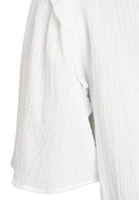 Valge tekstureeritud kangas peene ruudumustriga ja kortsus detailiga piki vertikaalset õmblust.