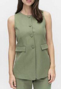 Olivgrön ärmlös väst med rund halsringning, fem matchande knappar och två framfickor. Slät tyg med skräddarsytt utseende.