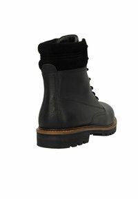 Zwarte leren enkelboot met een suède kraag, ronde neus en robuuste rubberen zool. Heeft veters en een gestikte detail langs de zijkant.