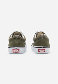 Zielone zamszowe sneakersy z białymi akcentami i gumową podeszwą, z czerwonym logo na pięcie. Zaprojektowane w niskim profilu i zaokrąglonym kształcie.