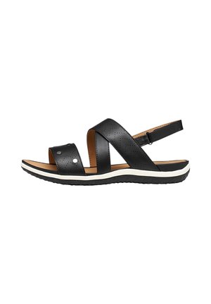 Sandale plate noire avec des brides croisées perforées, une bride arrière ajustable, une semelle intérieure rembourrée de couleur caramel et une semelle en caoutchouc blanche et noire texturée.