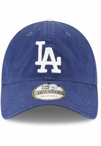 Modrá nastaviteľná baseballová čiapka s zakriveným okrajom. Na prednej strane je biele vyšívané logo "LA" a na okraji čiapky je látkový štítok.