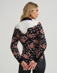 Blomstrete langermet skjorte i svart med rosa og hvite detaljer, med en kontrasterende hvit bærestykke og glatt tekstur.