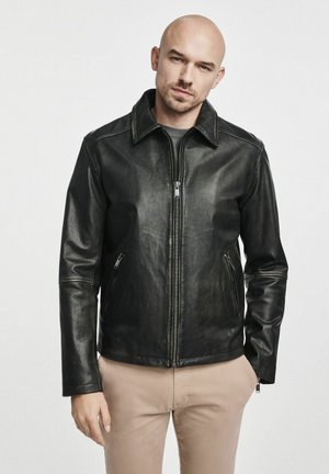 Czarna skórzana kurtka z kołnierzem, zapięciem na zamek z przodu i dwoma bocznymi kieszeniami. Gładka tekstura, dopasowany krój i minimalne akcenty w hardware.