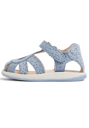 Blauwe suède sandaal met uitsnijdingen, verstelbare klittenbandsluiting, gestructureerde witte zool en subtiele glittertjes op het materiaal.