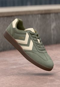 Grüne Wildledersneaker mit beigen Lederakzenten, strukturiertem Zungenbereich, geschichteter Chevron-Design und brauner Gummisohle. Mit "VM78 CPH" Branding.