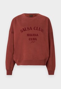Sweat-shirt couleur rouille avec le texte "SALSA CLUB HAVANA CUBA" imprimé sur le devant, avec poignets et ourlet côtelés.
