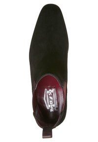 Musta mokkanahkakenkä, jossa on terävä kärki, burgundy-väri sisävuoraus ja kantatangot. Kengässä on sileä pinta ja hienovarainen brändäys sisäpuolella.