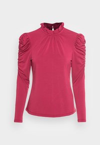 Rosa långärmad blus med veckade puffärmar och en volangkrage, uppvisad mot en vit bakgrund.