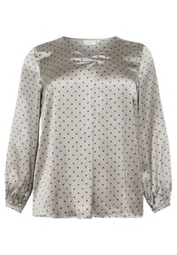 Blouse en satin gris clair avec des pois noirs, décolleté en V et manches longues élastiques. Texture lisse et coupe décontractée.