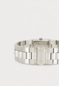 Silver stainless steel watch with a square case and link bracelet. Features polished and brushed metal finishes with a clasp closure.