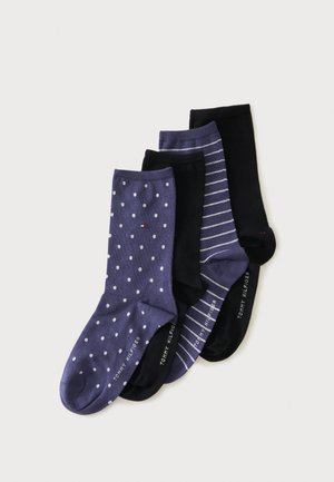 Quatre paires de chaussettes Tommy Hilfiger en bleu à pois blancs, noir uni, bleu à rayures blanches et noir uni, soigneusement alignées.