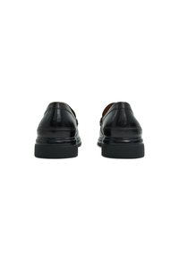 Black leather shoes with a smooth finish, featuring a low heel and rounded toe. Stitch detailing along the back and sides.