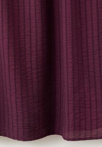 Tissu bordeaux avec des lignes verticales cousues créant un motif rayé texturé, montré en gros plan.