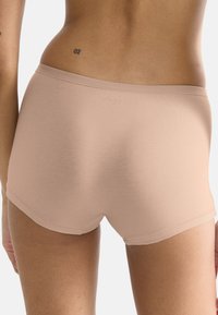 Beżowe szorty Sloggi wykonane z miękkiego, elastycznego materiału; gładka faktura z prostym wzorem i logo blisko pasa.