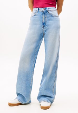 Lyseblå vidde jeans lavet af denim, med høj talje, lige snit og subtil falmning. Båret med hvide sneakers.