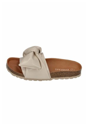 Beige slide sandal with a knotted bow detail, shiny synthetic upper, cork footbed, and textured sole. Flat design suitable for casual wear.