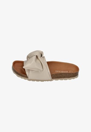 Beige slide sandal with a knotted bow detail, shiny synthetic upper, cork footbed, and textured sole. Flat design suitable for casual wear.