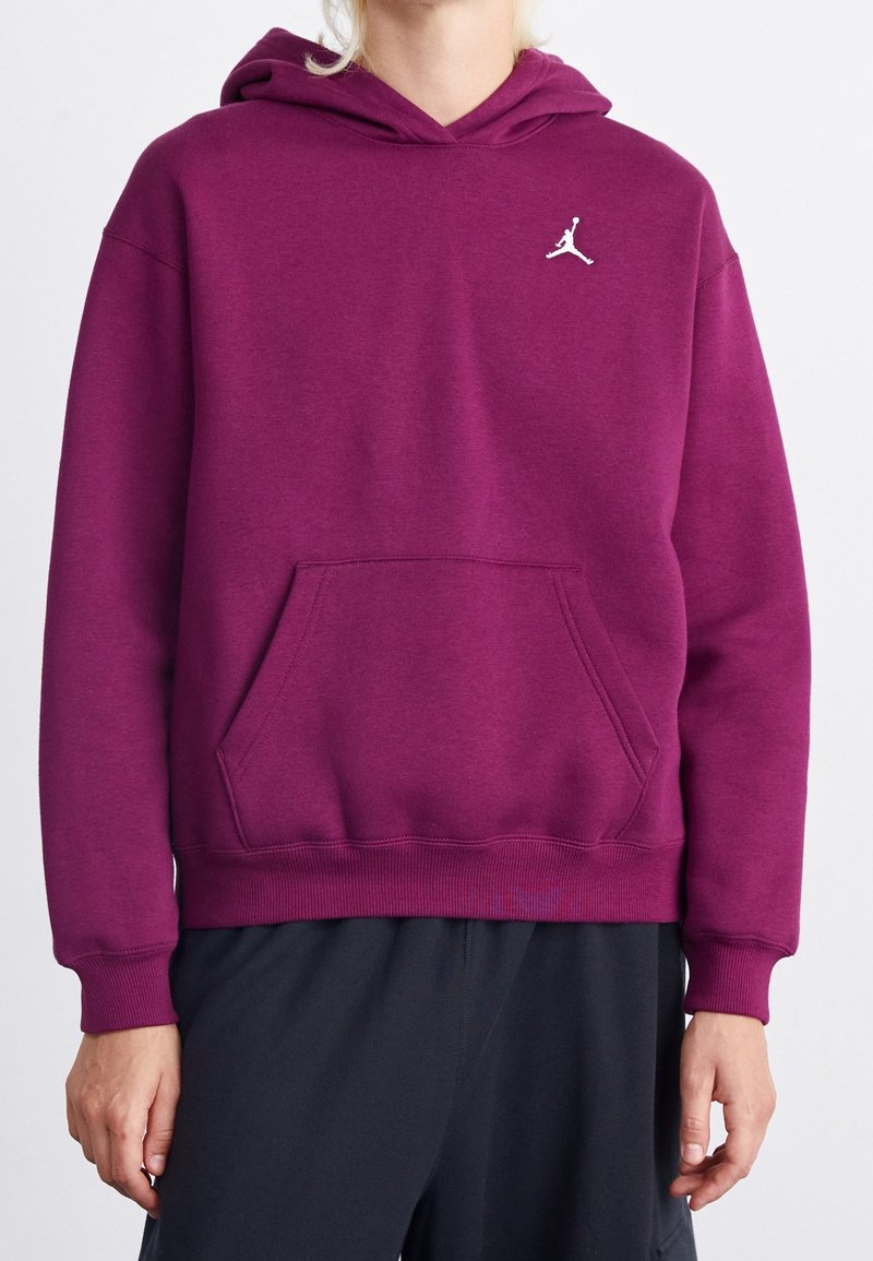 Sudadera morada hecha de una tela de textura suave. Presenta un bolsillo frontal y un logo Jumpman blanco en el pecho. Puños y dobladillo acanalados.