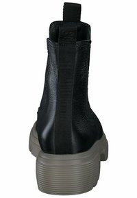 Bottines noires avec une finition en cuir lisse, des panneaux latéraux élastiques et une semelle plateforme striée gris clair pour plus de hauteur.