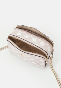 Růžová syntetická křížová taška s bílými logy, dvě zipové přihrádky a řetízek ve zlatém tónu. Hladký povrch, kompaktní tvar.