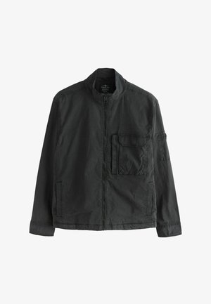 Tumši pelēka ikdienas jaka ar priekšējo rāvējslēdzēju, augstu apkakli un vairākiem kabatām uz krūtīm un piedurknēm, izvietota guļus uz balta fona.