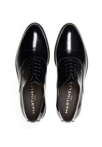 Pair of polished black leather dress shoes with laces, viewed from above, showing "Martinelli 1973" gold logo inside.