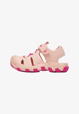 Sandalia infantil Reebok de color rosa claro con cierre ajustable, orificios de ventilación y suela y cordones de color rosa intenso.