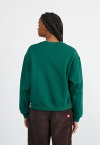 New Balance ATHLETICS CREST CREW - Mikina - nightwatch green