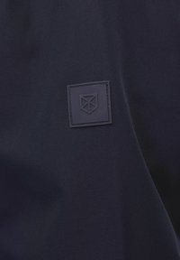 Námornícka tkanina s embosovaným štvorcovým zlatým vzorom. Hladký povrch s matným finishom, minimalistický dizajn, bez ďalších vzorov.