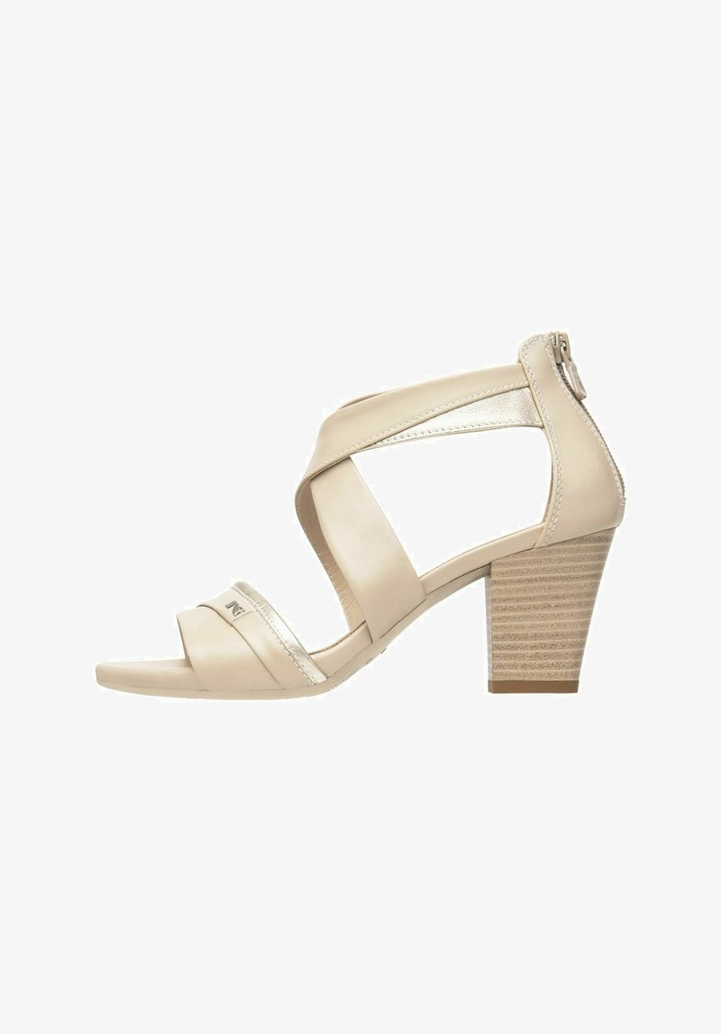 Beige open-toe heeled sandal with cross-strap design, metallic accents, and a textured block heel. Side zipper for secure fit.