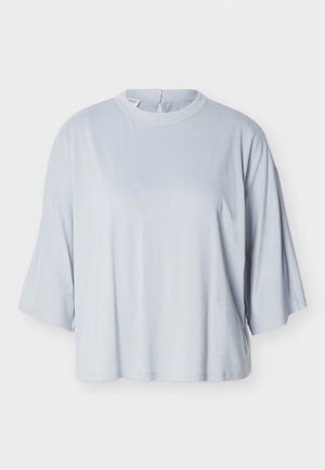 Lichtblauw loszittend shirt met brede mouwen tot de elleboog en een ronde hals, getoond op een effen witte achtergrond.