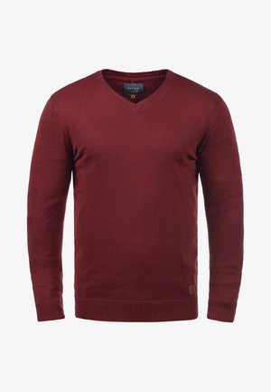 Burgunderfarbener Strickpullover mit V-Ausschnitt, langen Ärmeln, gerippten Bündchen und Saum sowie einem kleinen Stofflogo an der unteren Seite.