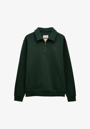 Tume roheline pika varrukaga pullover pooltõmblukuga ees, ülesseisva kraega, soonikute ja alläärega ning väike logo vasakul rinnal.