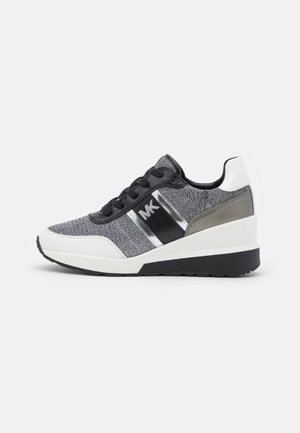 Baskets femme grises et blanches avec lacets noirs, semelle compensée et logo "MK" sur le côté, présentées sur fond blanc.