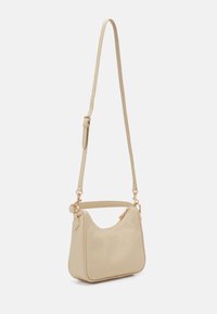 Sac à bandoulière en cuir souple beige avec une fine sangle réglable, des ferrures métalliques dorées et une fermeture zippée sur le dessus.