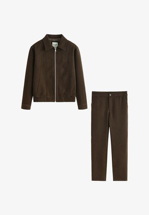 Veste marron zippée avec col, tissu texturé et ourlet élastique. Pantalon assorti marron avec taille élastique et un seul bouton.