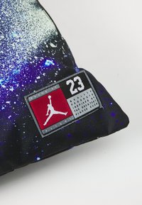 Crna jastuk s kozmičkim plavim i bijelim točkicama. Ima crvenu i sivu oznaku s Jumpman logotipom i tekstom "23".