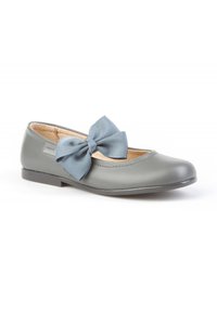 Zapato plano de cuero gris con punta redondeada, tacón bajo y gran lazo de tela azul en la parte superior, presentado sobre fondo blanco.